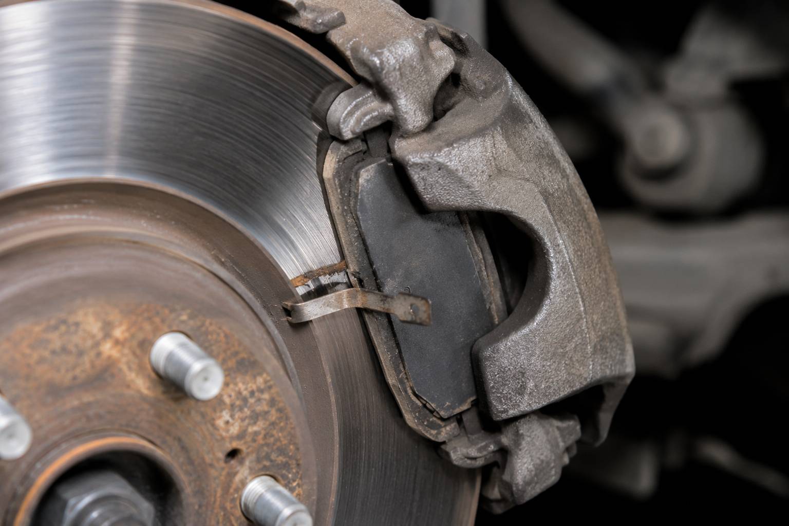 The metal wear indicator tab scrapes the rotor to warn you of low pad thickness